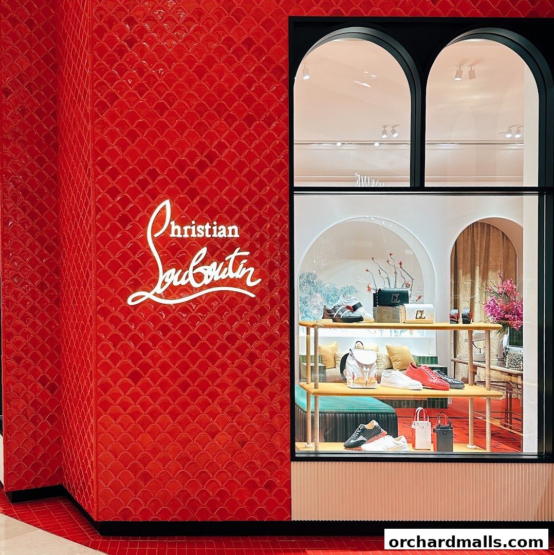 Christian Louboutin store window display featuring shoes and handbags on shelves.