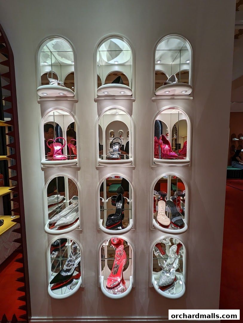 A display wall showcasing various Christian Louboutin high heels in arched niches.