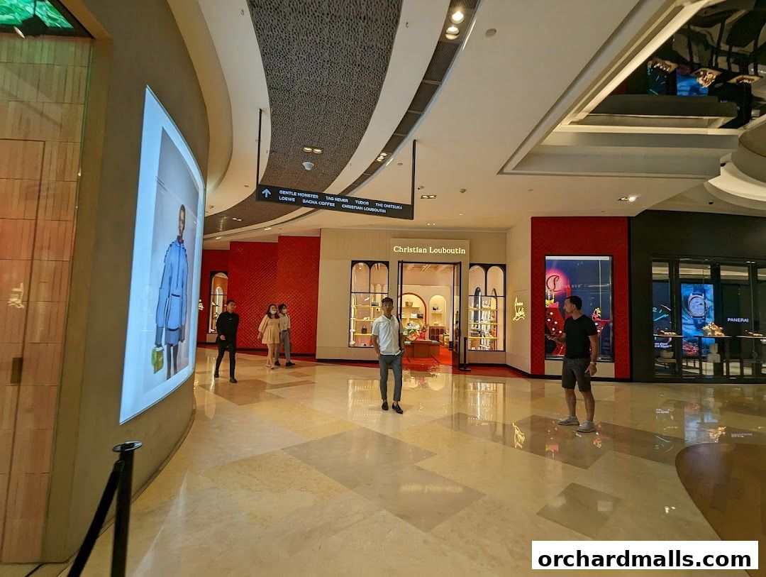 The Christian Louboutin store entrance in a modern shopping mall with shoppers nearby.