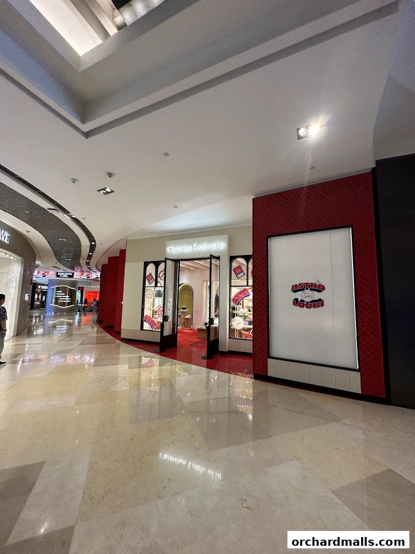 The Christian Louboutin store entrance at ION Orchard, Singapore, with its iconic red carpet and displays.