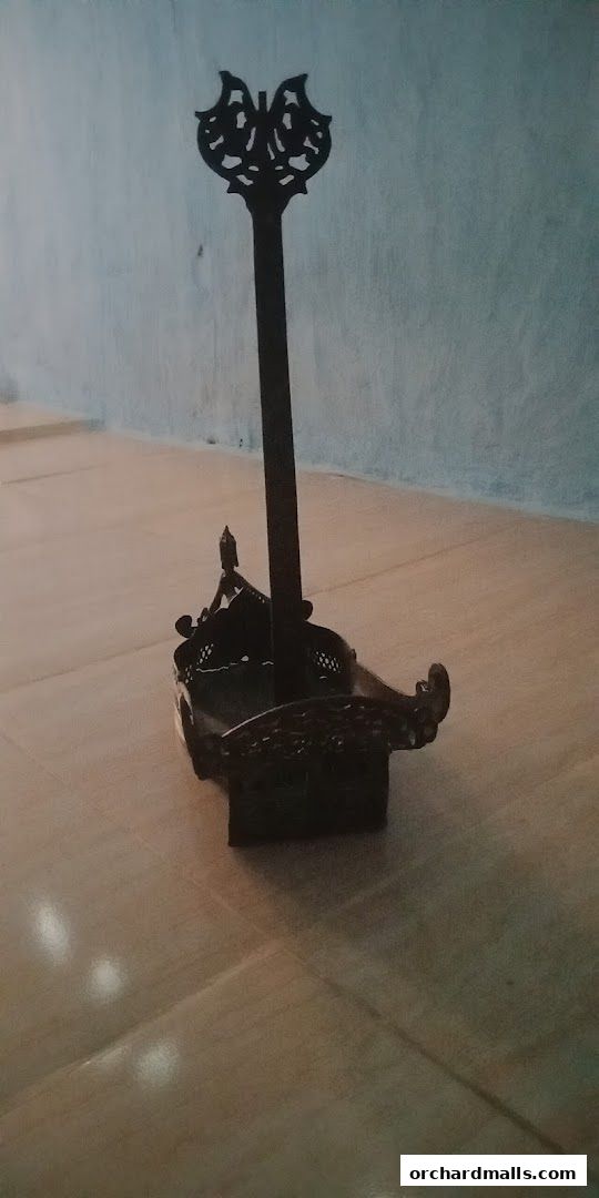 A decorative metal stand with intricate carvings, possibly for display or holding items.