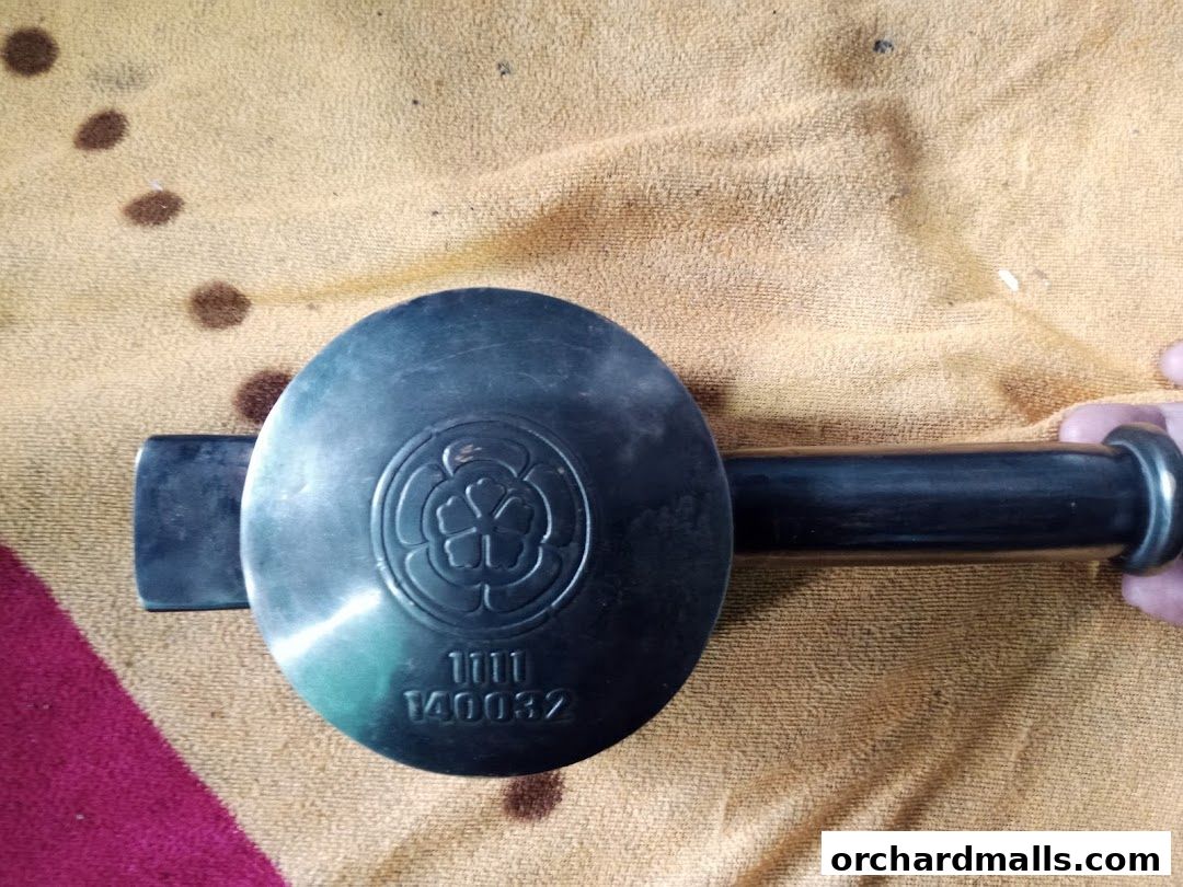 A close-up of a metal object with a circular emblem and engraved numbers.