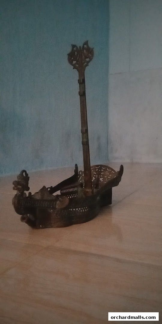 An ornate, antique-style brass ship model with intricate detailing.