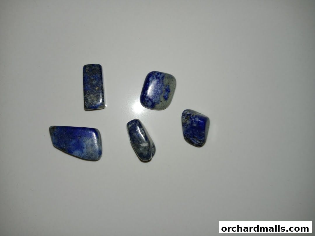 Several polished lapis lazuli stones are displayed on a white surface.
