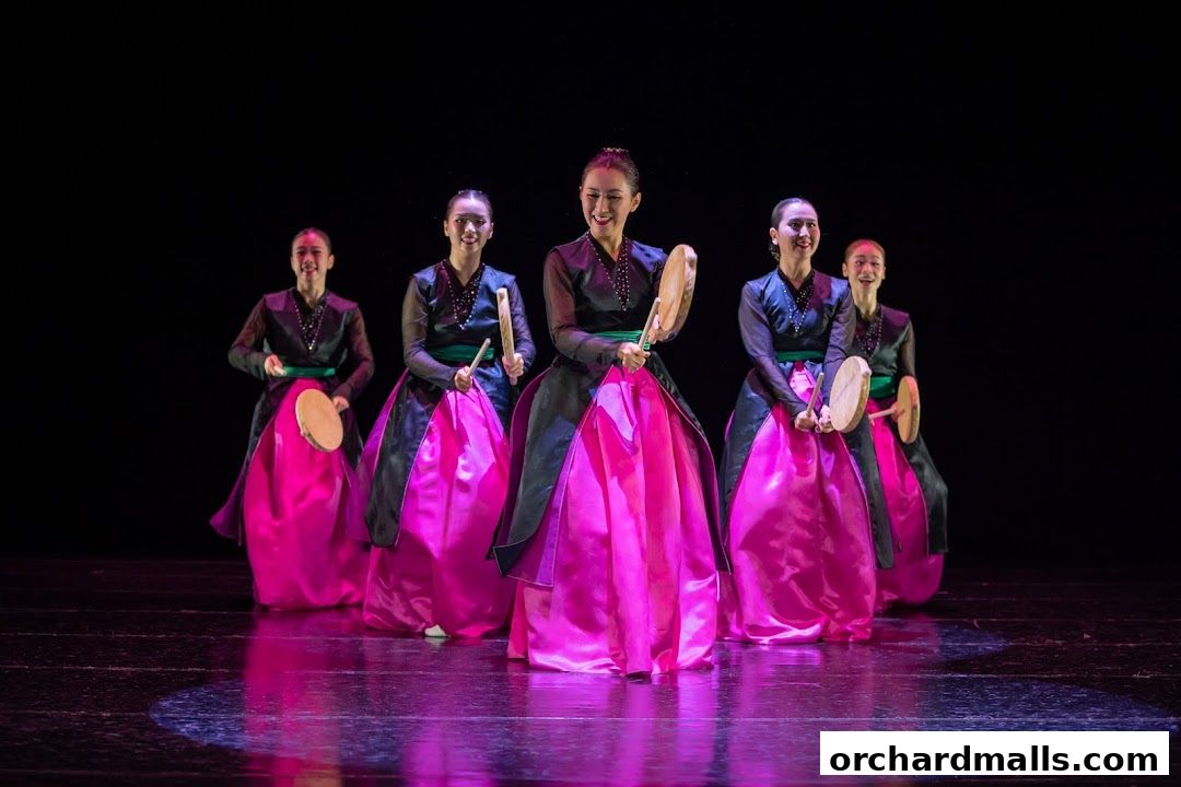 Five women in traditional Korean attire perform a drum dance on a stage.
