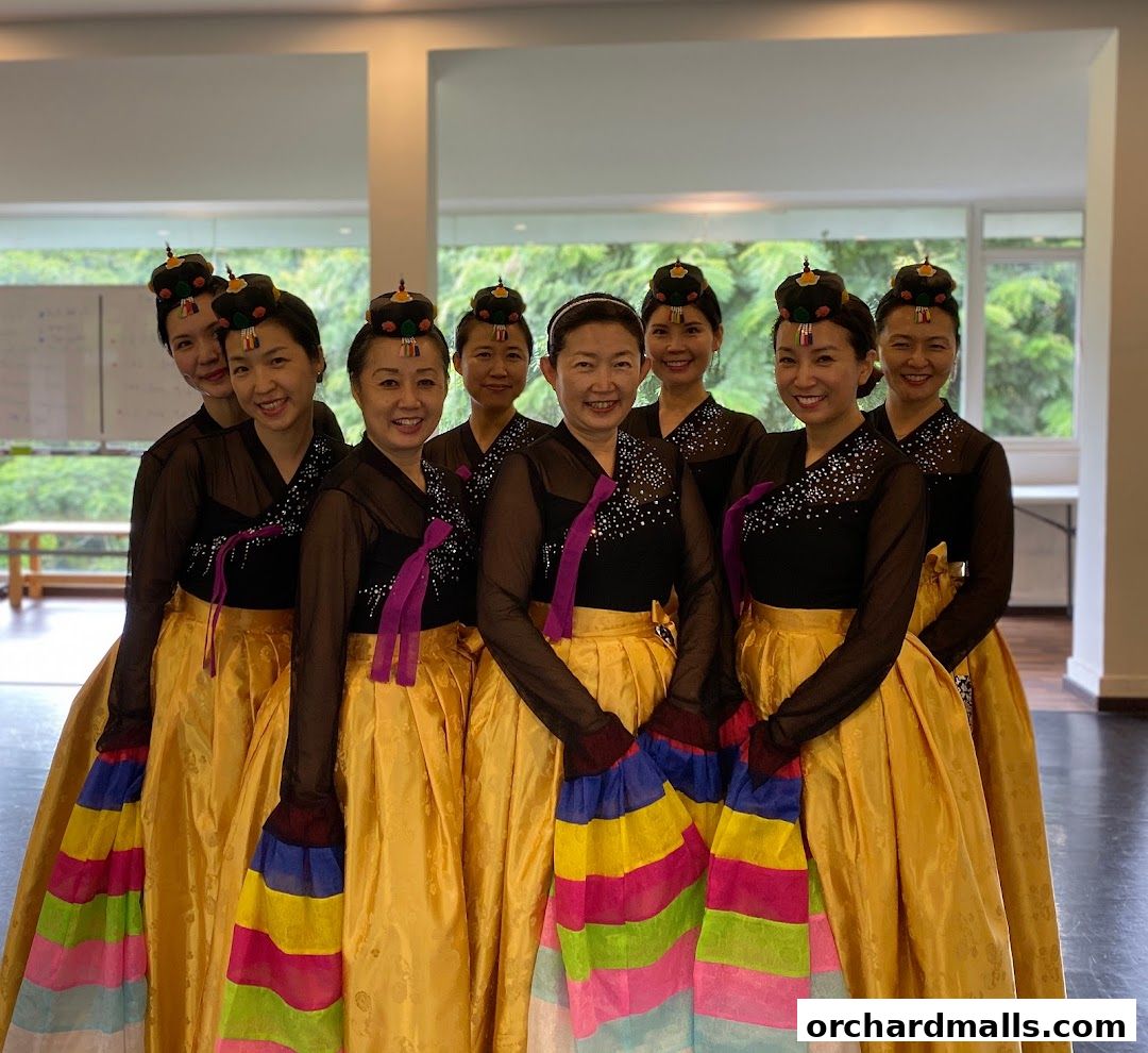 Group of women in traditional Korean Hanbok attire posing for a photo.