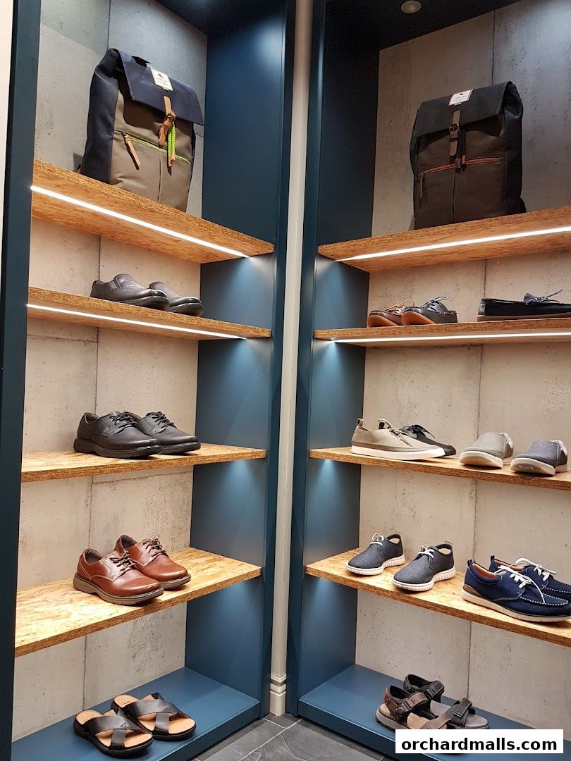A display of various shoes and backpacks on shelves in a retail store.