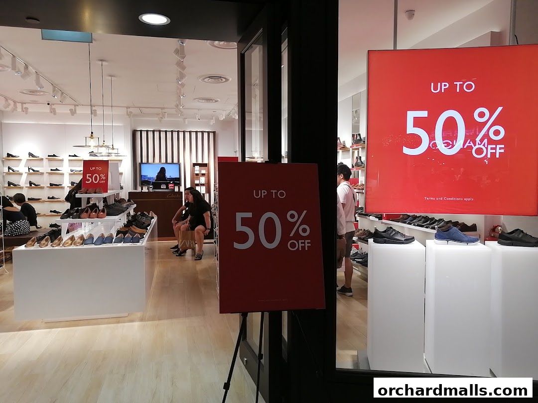 Clarks shoe store interior with sale signs and displays of shoes.