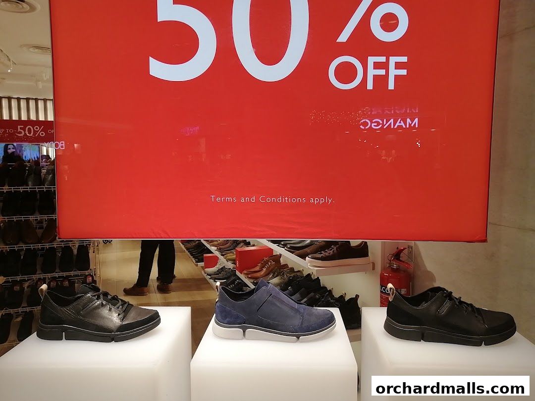 Clarks shoe store display featuring a large '50% OFF' sign and several pairs of stylish shoes.