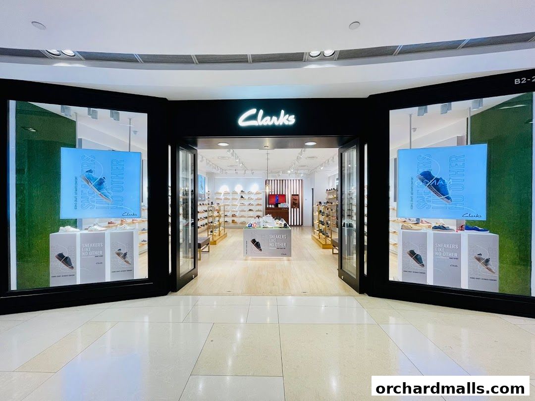 The entrance to a Clarks shoe store, showcasing various footwear and promotional displays.