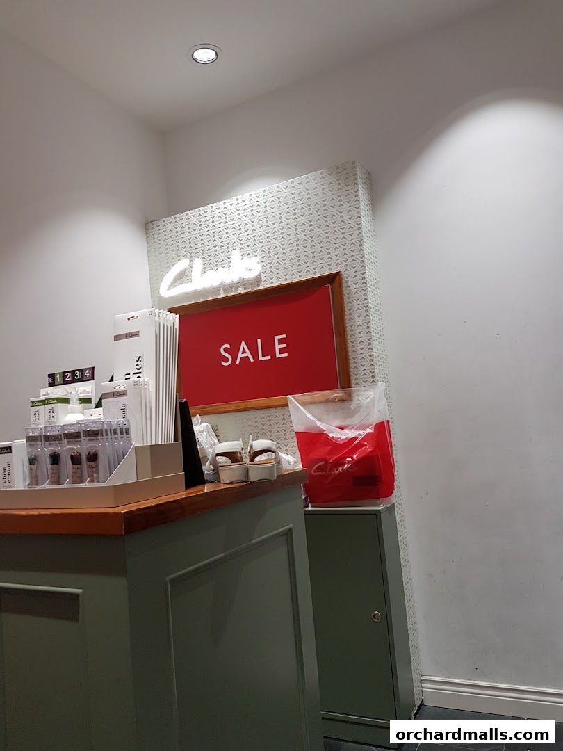 Clarks shop interior with a prominent 'SALE' sign and various shoe care products displayed.