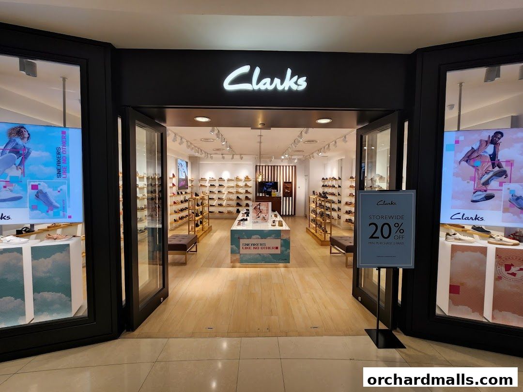 The entrance to a Clarks shoe store, showcasing footwear and a 20% off storewide promotion.