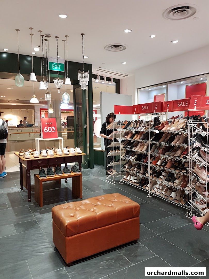 Interior of a Clarks shoe store with a large selection of shoes on display and a sale sign.
