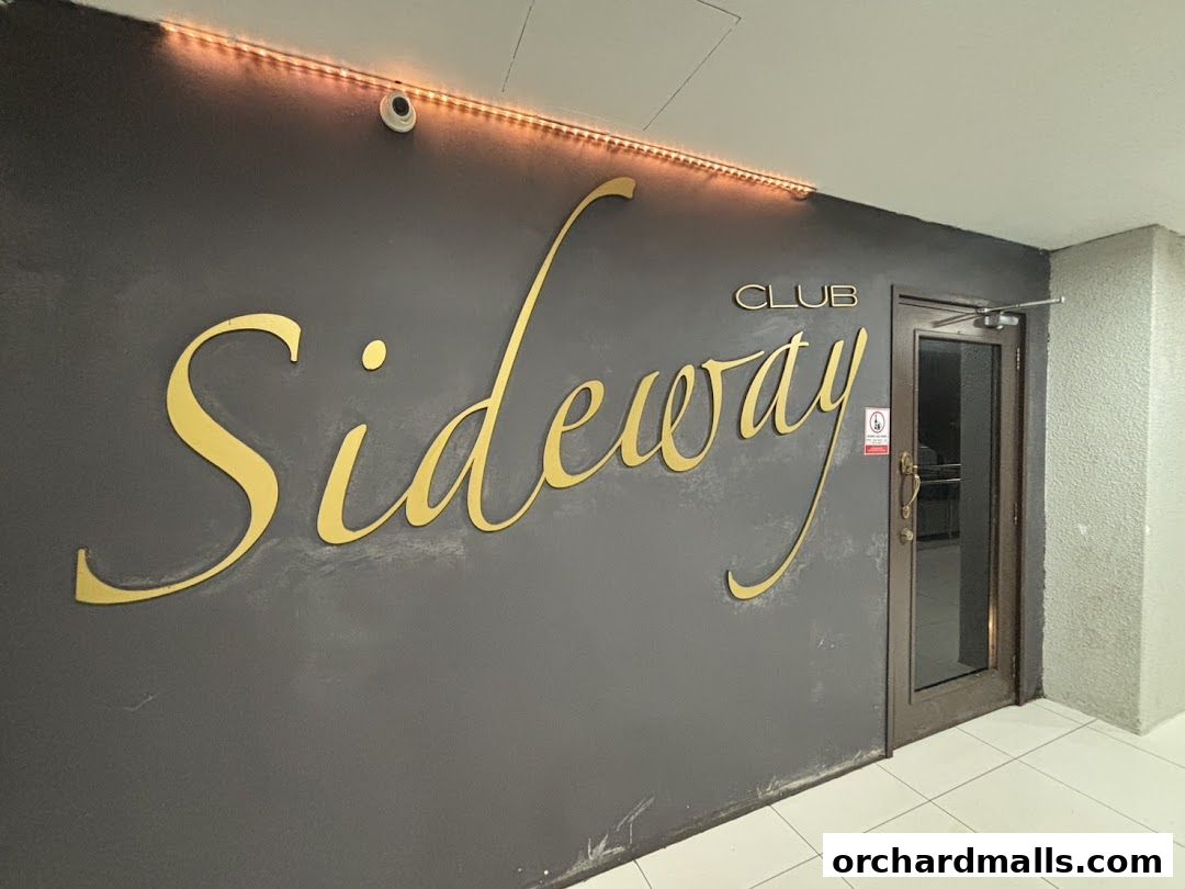 The entrance to Club Sideway, featuring a large golden sign and a glass door.