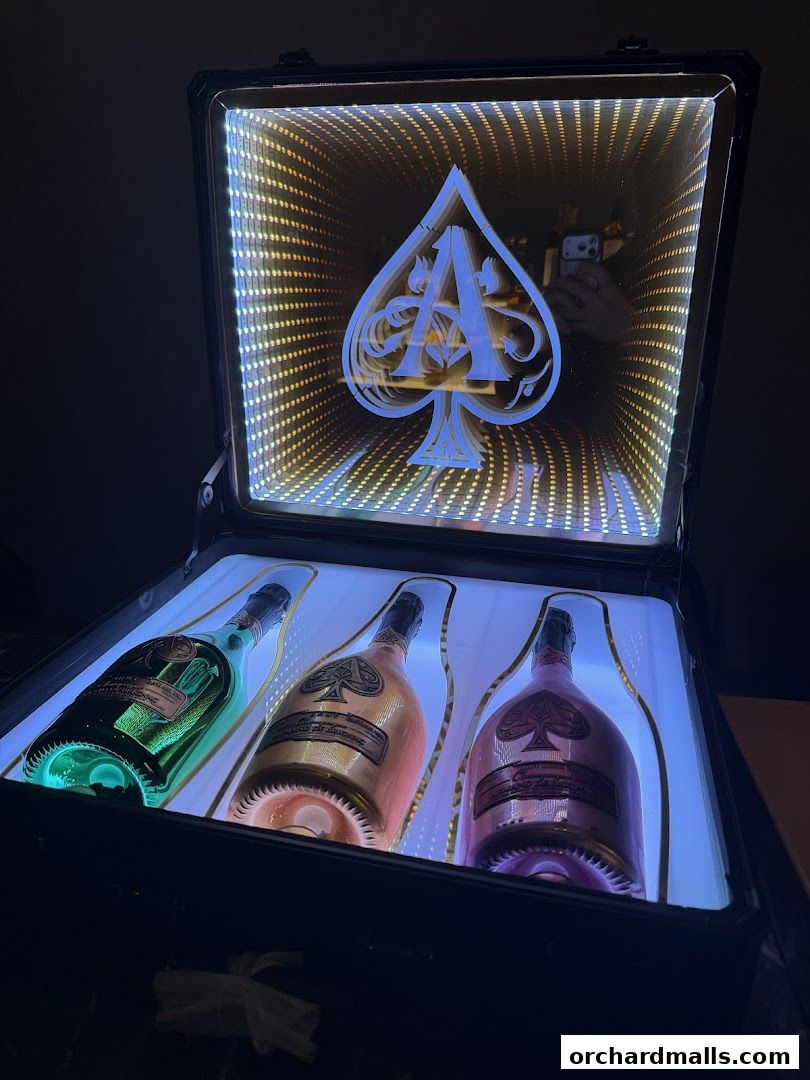 Three bottles of Ace of Spades champagne displayed in a lighted case with an infinity mirror effect.