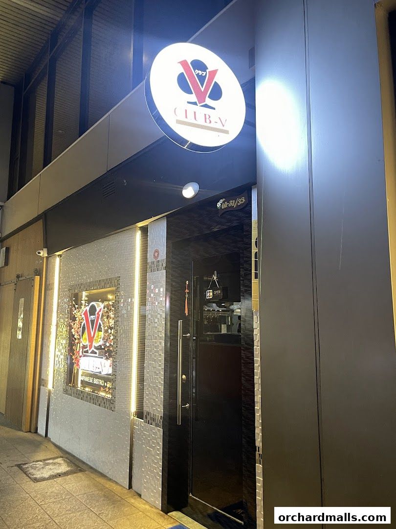 Exterior of CLUB-V Bistro bar with illuminated signage and entrance.