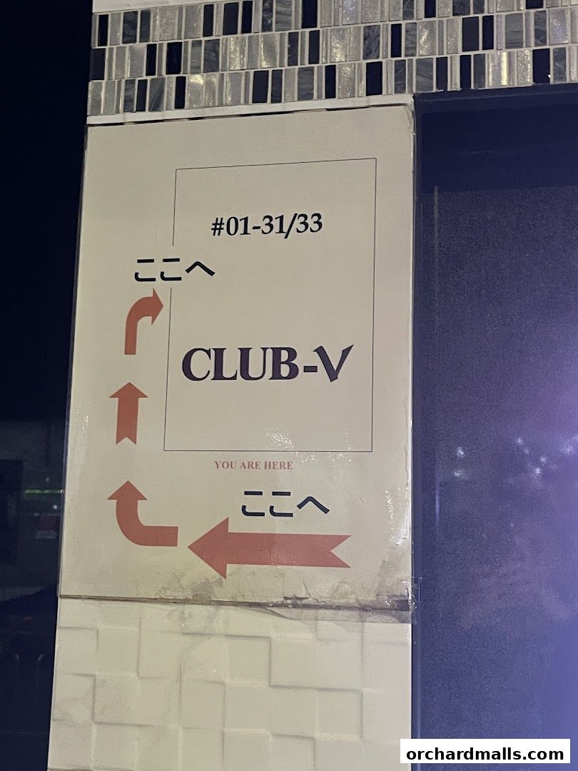 Signage for CLUB-V Bistro bar with directional arrows and unit numbers.