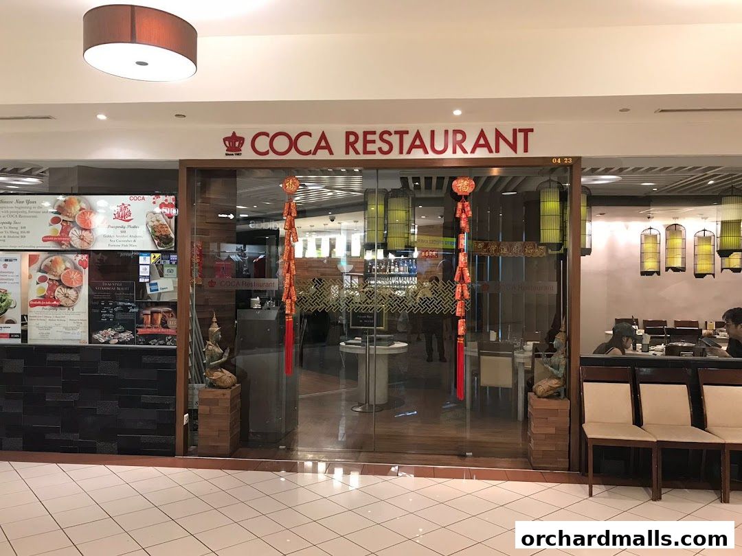 The entrance of COCA RESTAURANT with a menu display and seating visible inside.