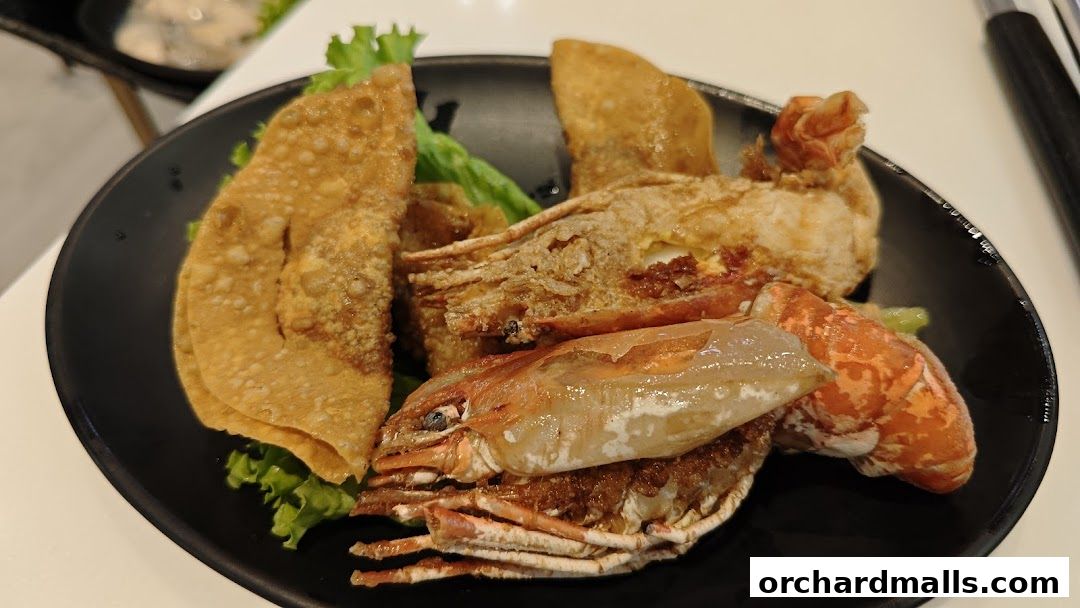 A plate of fried seafood and wontons served with lettuce.