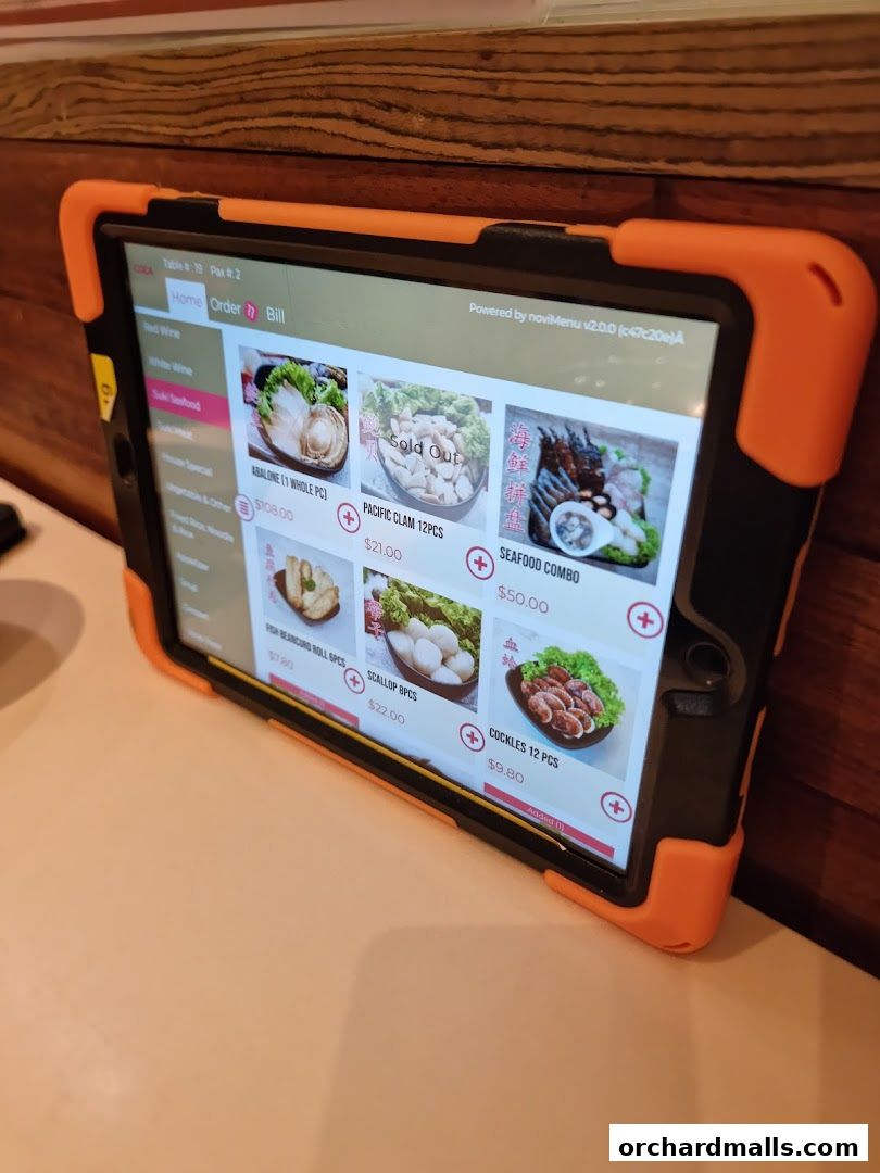 A tablet displaying a digital menu for a seafood restaurant with various dishes and prices.