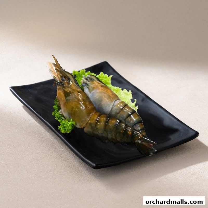 Two large, fresh prawns served on a black plate with lettuce.