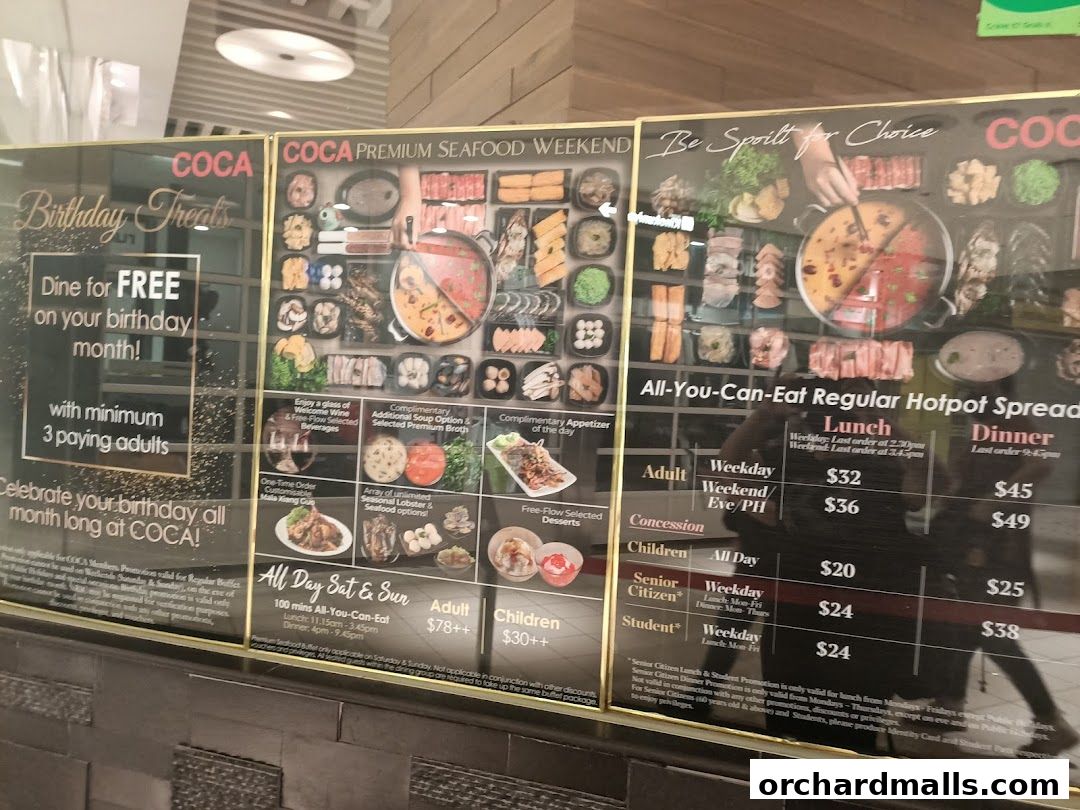 A display board for COCA restaurant showcasing birthday treats and all-you-can-eat hotpot promotions.