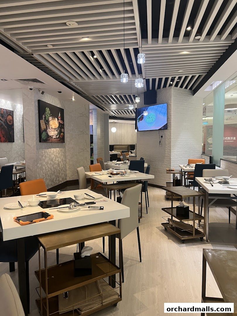 Interior of a modern restaurant with tables set for dining and decorative wall art.