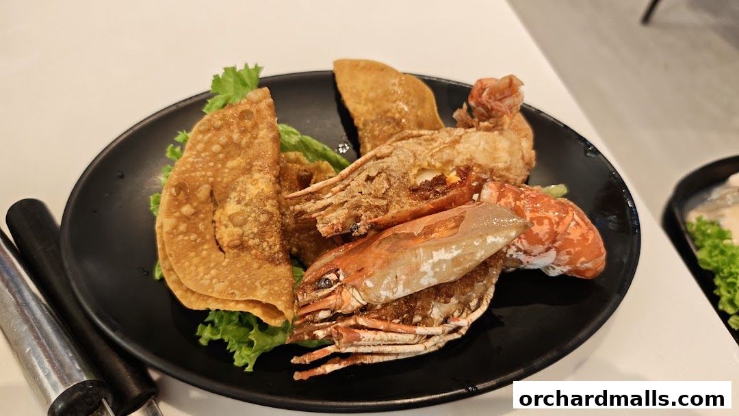 A plate of fried seafood and wontons served on a bed of lettuce.