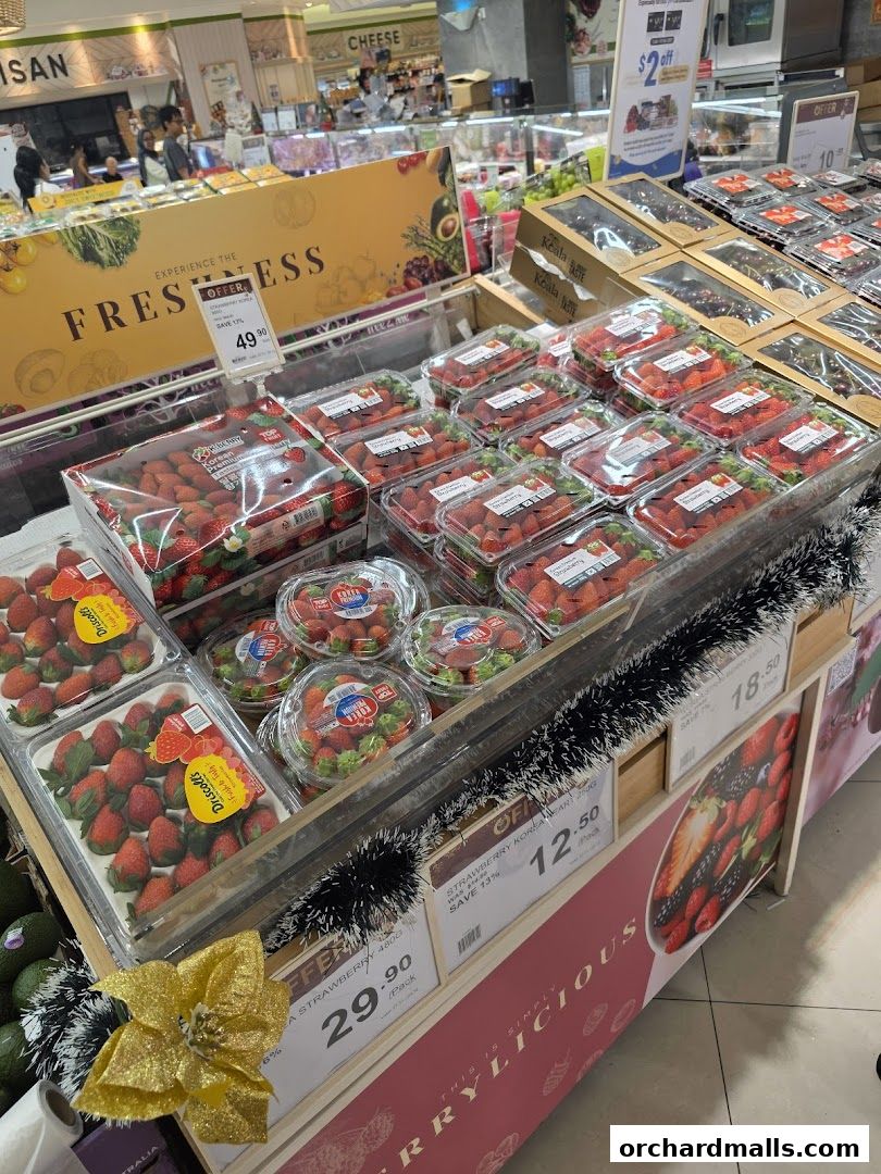 A display of fresh strawberries and other fruits at a grocery store.