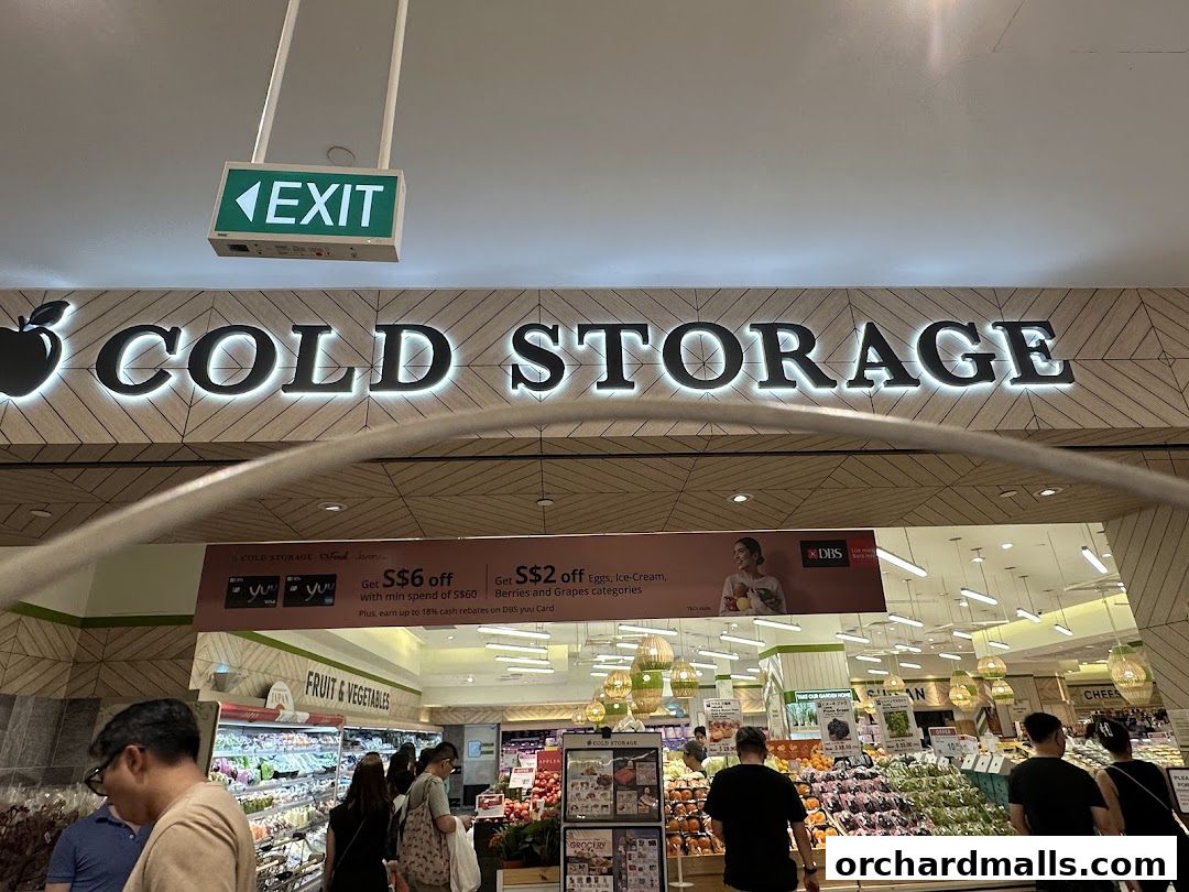 The entrance to Cold Storage supermarket with illuminated signage and promotional banners.