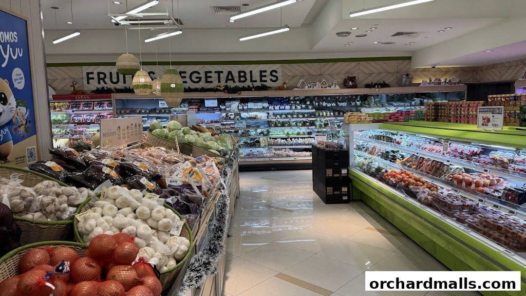 A well-stocked grocery store aisle featuring fresh produce like onions, garlic, and vegetables.