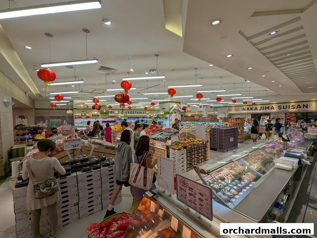 Interior view of a well-stocked supermarket with fresh produce and prepared foods.