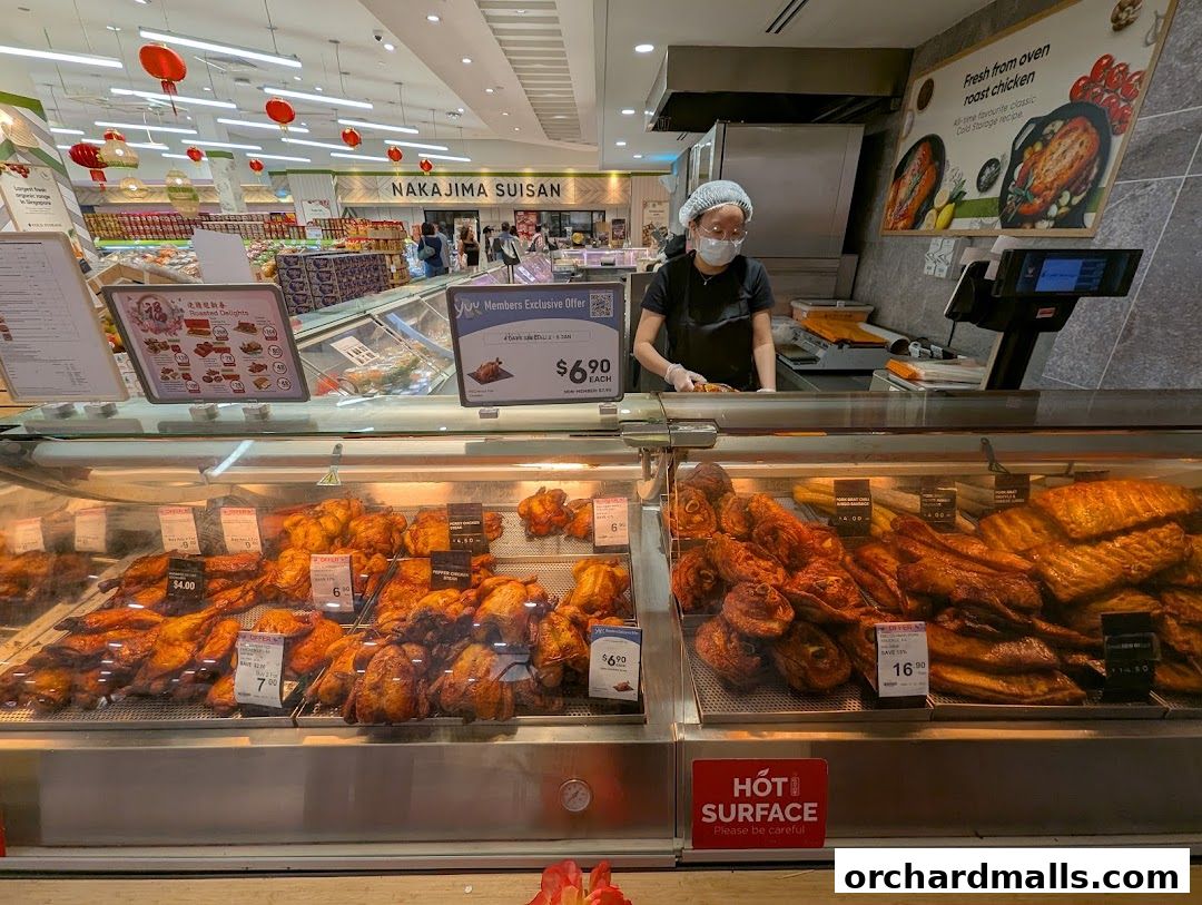 A display of roasted chickens and other meats at a Cold Storage supermarket.