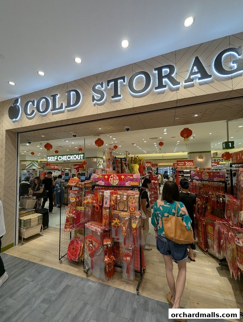 Entrance of Cold Storage supermarket with festive decorations and shoppers.