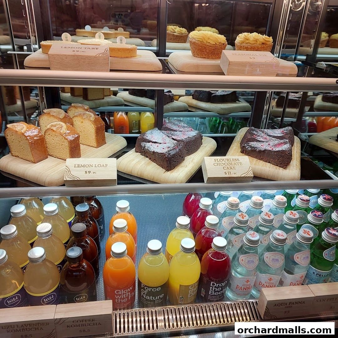 A display case filled with various baked goods and bottled beverages.