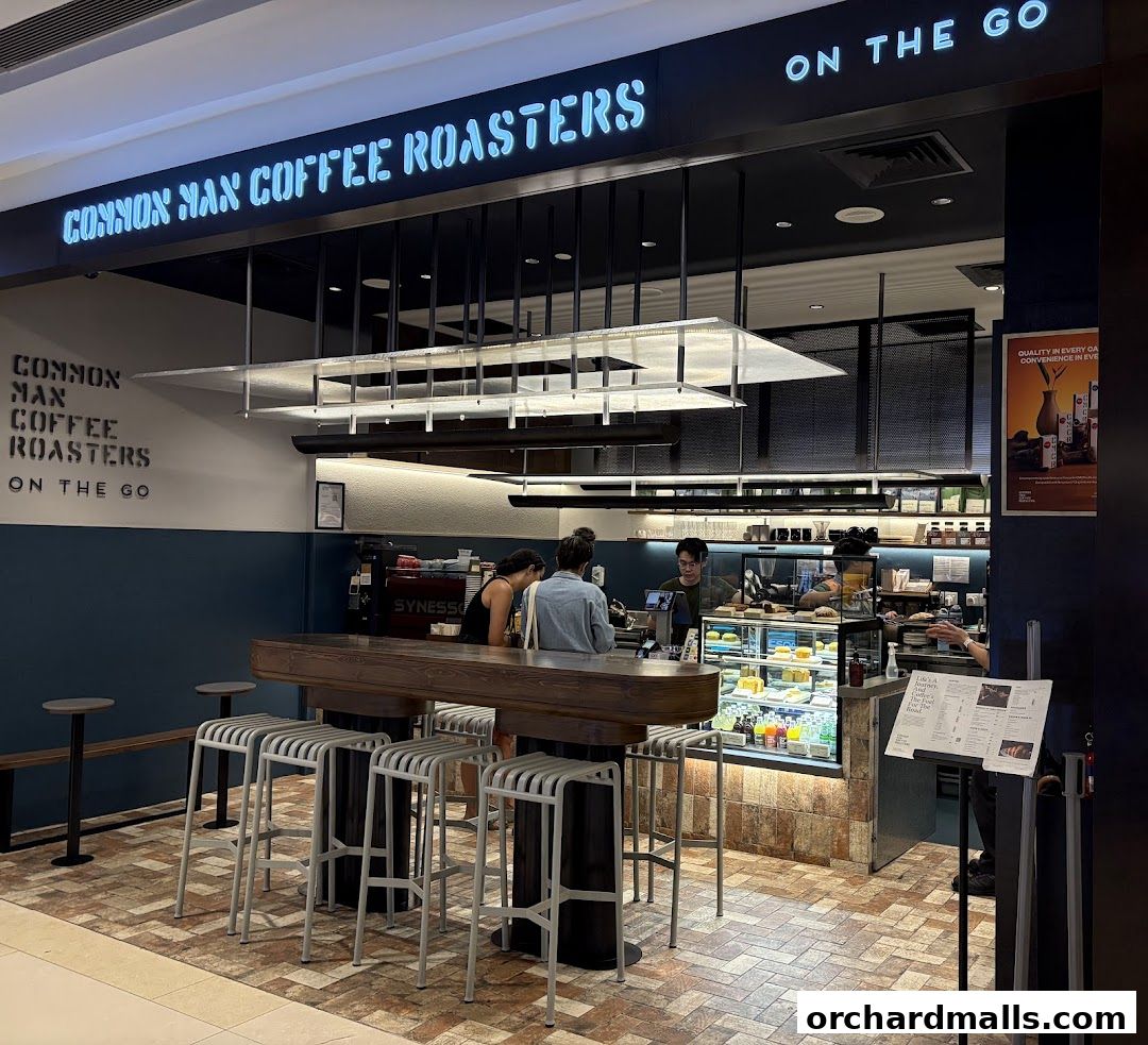 A modern coffee shop interior with a counter, seating, and display cases.