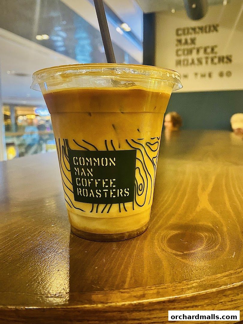 A refreshing iced coffee from Common Man Coffee Roasters on a wooden table.