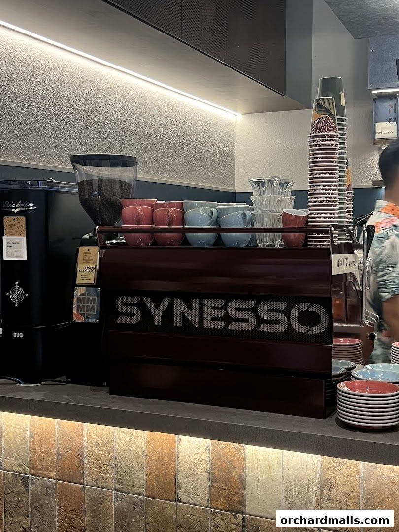 A coffee machine with cups and coffee beans on a counter.