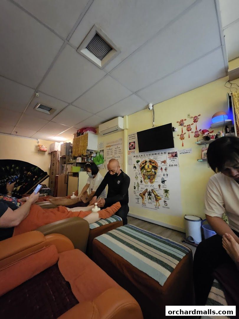 Therapists giving foot massages to clients relaxing in comfortable chairs at Complete Wellness.