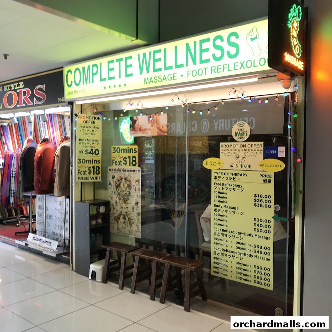 The exterior of Complete Wellness, a massage and foot reflexology shop, with promotional offers displayed.