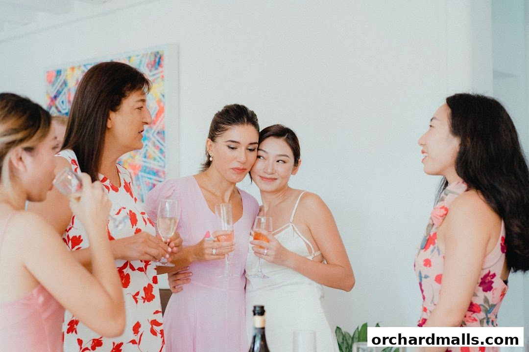 Women in dresses holding glasses of champagne at a celebration.