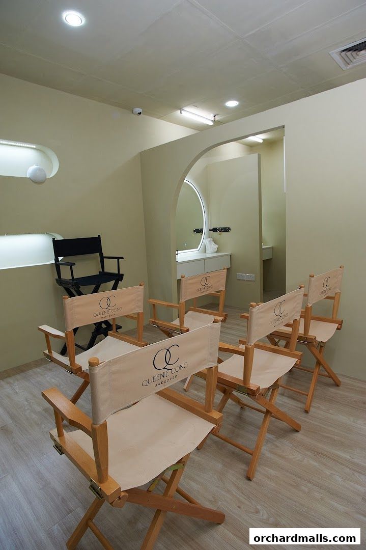 Interior of a makeup academy with director chairs and a vanity area.