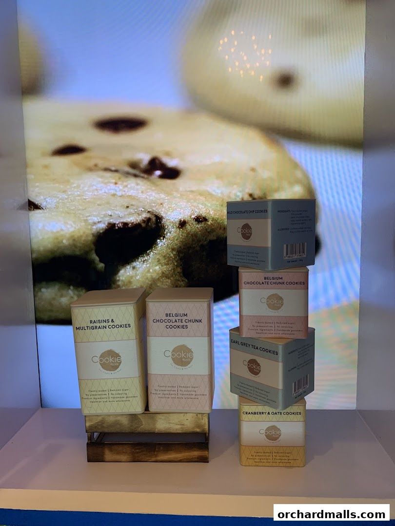 A display of various Cookie Mixx cookie boxes with a large cookie image in the background.