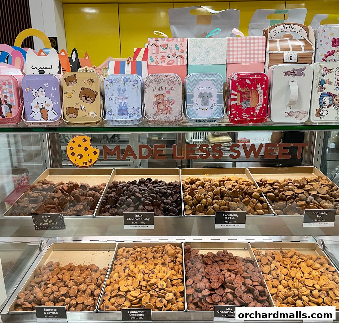 Display of various cookie flavors in tins and trays at Cookie Mixx.