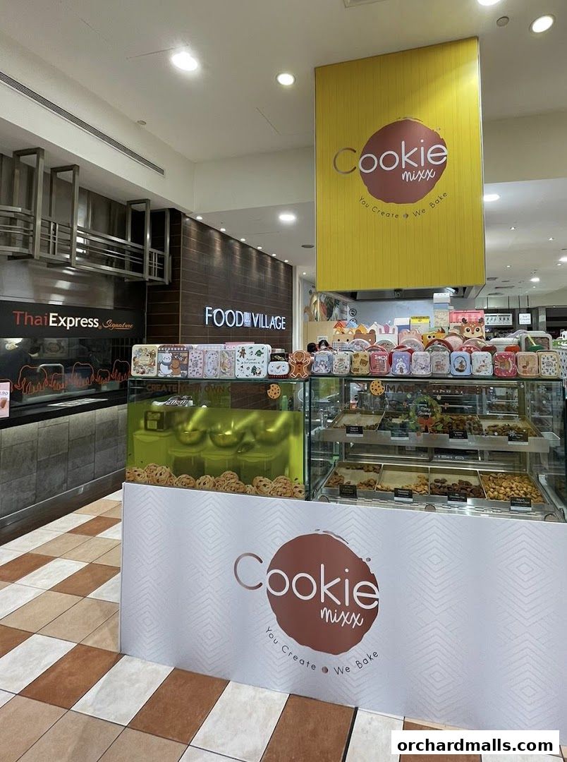 A Cookie Mixx shop display with various cookies and cookie tins in a food court.