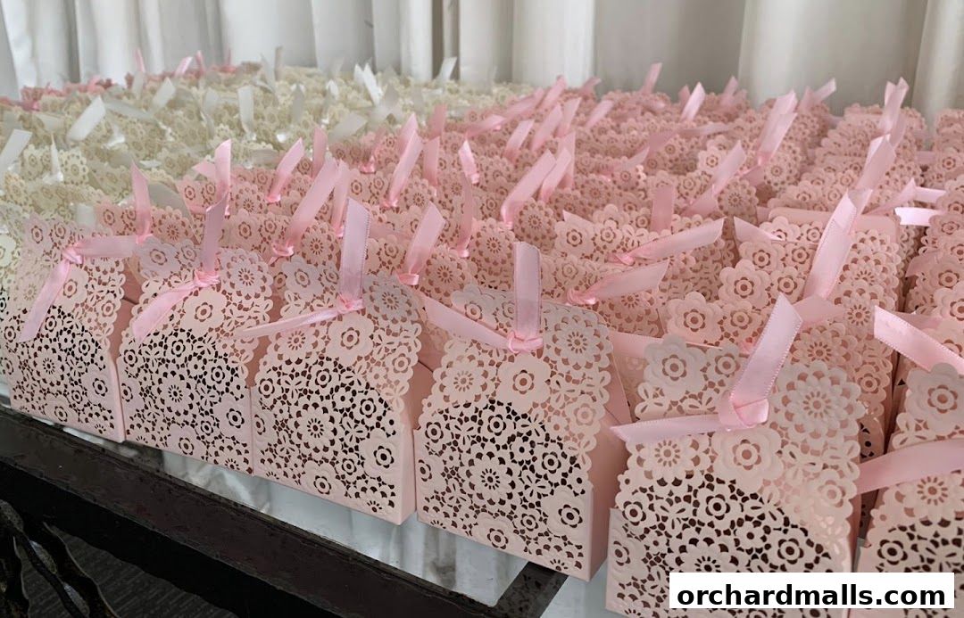 Rows of delicate pink and white gift boxes with intricate floral cutouts and pink ribbons.