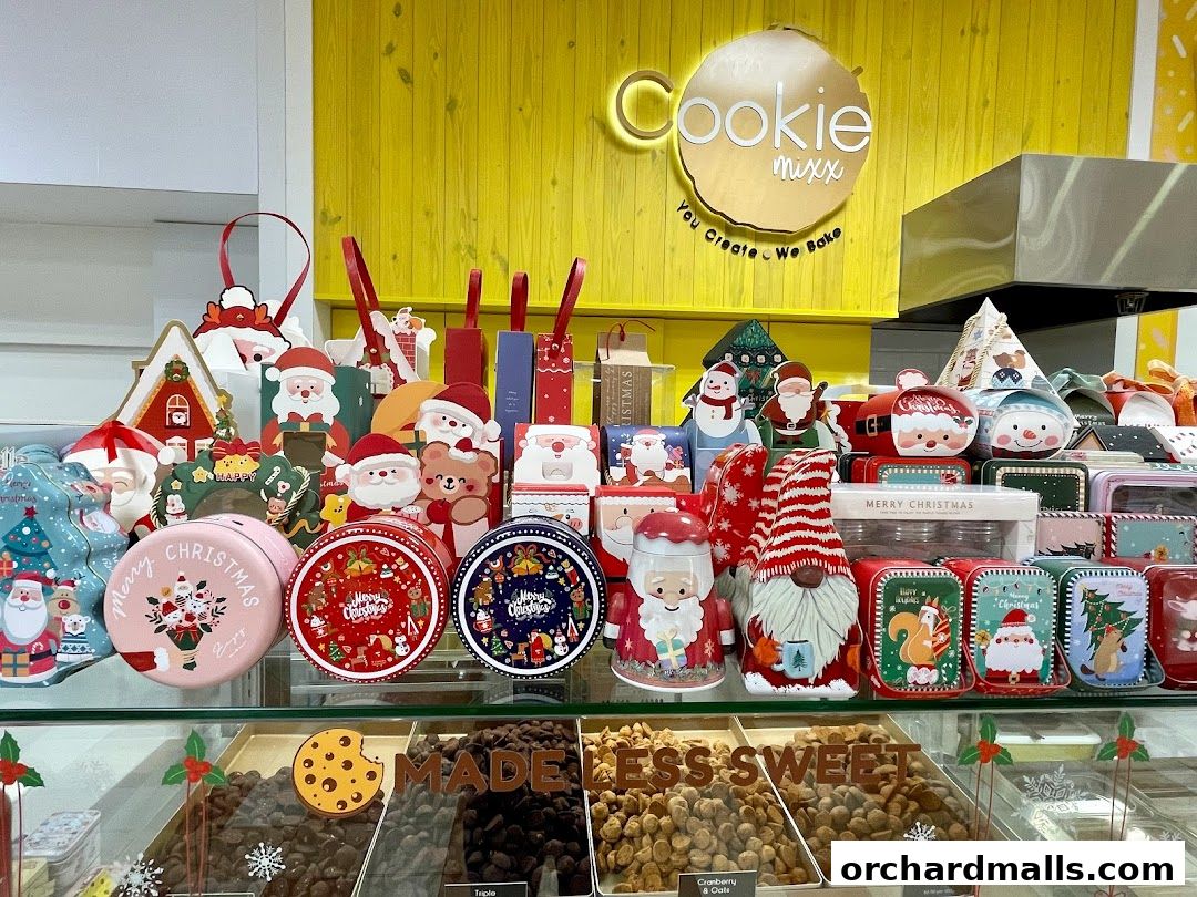 A display of Christmas-themed cookie tins and bulk cookies at Cookie Mixx.