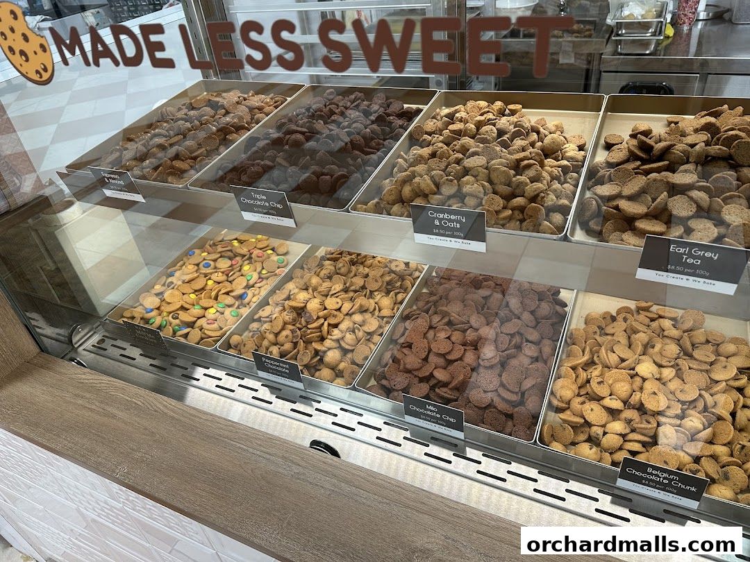 A display case filled with various types of small, round cookies.