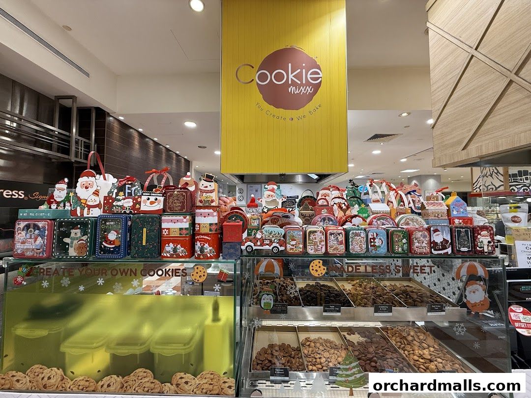 A display of Christmas-themed cookie tins and bulk cookies at Cookie Mixx.