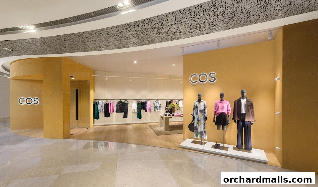 Interior view of a COS store showcasing clothing on racks and mannequins.